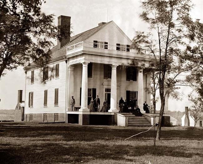 Farmhouse house plans: Historic photograph of an early American farmhouse with a two-story columned porch | Monster House Plans