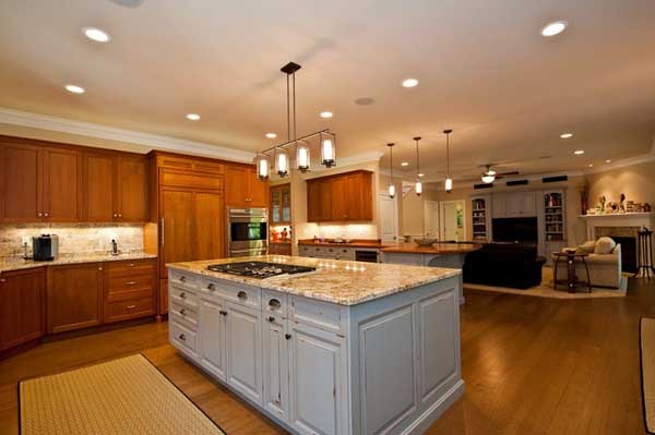Farmhouse house plans: Farmhouse house plan interior with an open kitchen, island seating, and adjoining living area | Monster House Plans
