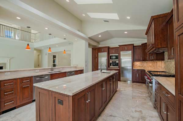 Luxury house plans: Luxury house plan interior kitchen with an oversized island, wood cabinetry, and stone counters | Monster House Plans
