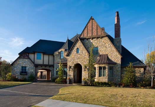 Tudor house plans: Tudor house plan exterior with a stone facade, steep cross gables, and a prominent chimney | Monster House Plans