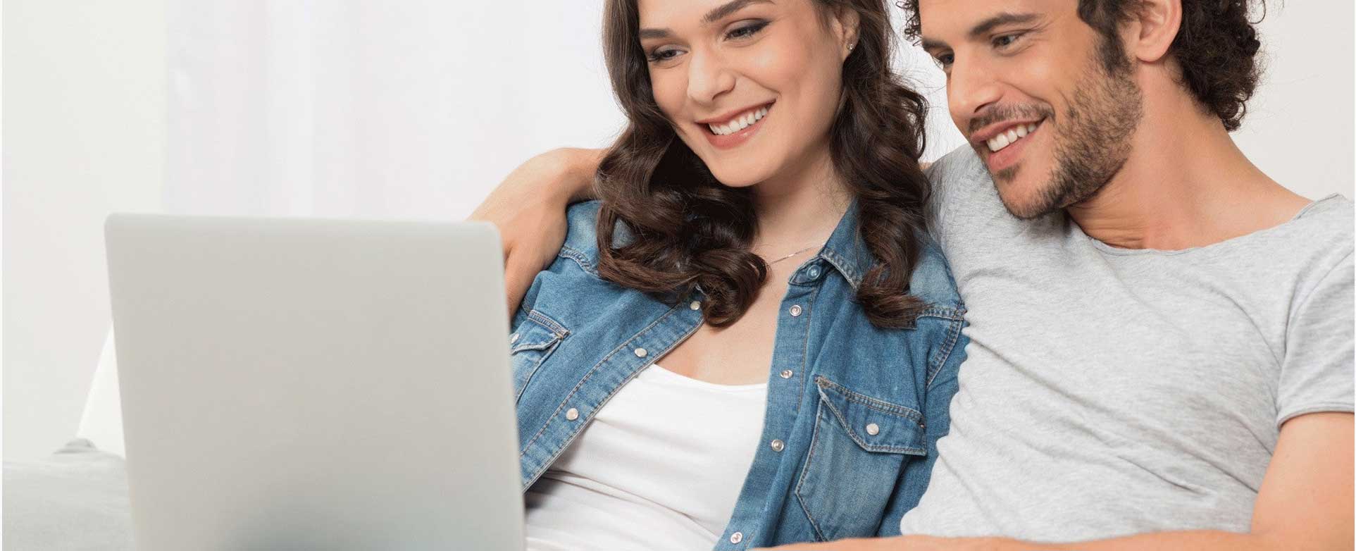 A couple browsing house plans together on a laptop | Monster House Plans